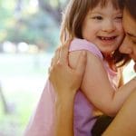 Woman with specials needs child, both embracing and smiling