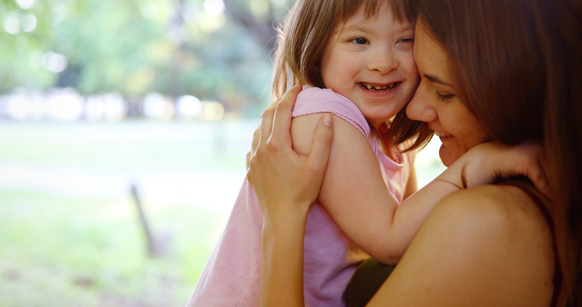 Woman with specials needs child, both embracing and smiling
