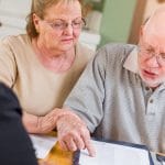 Senior adult couple reviewing estate planning documents with their estate planning lawyer