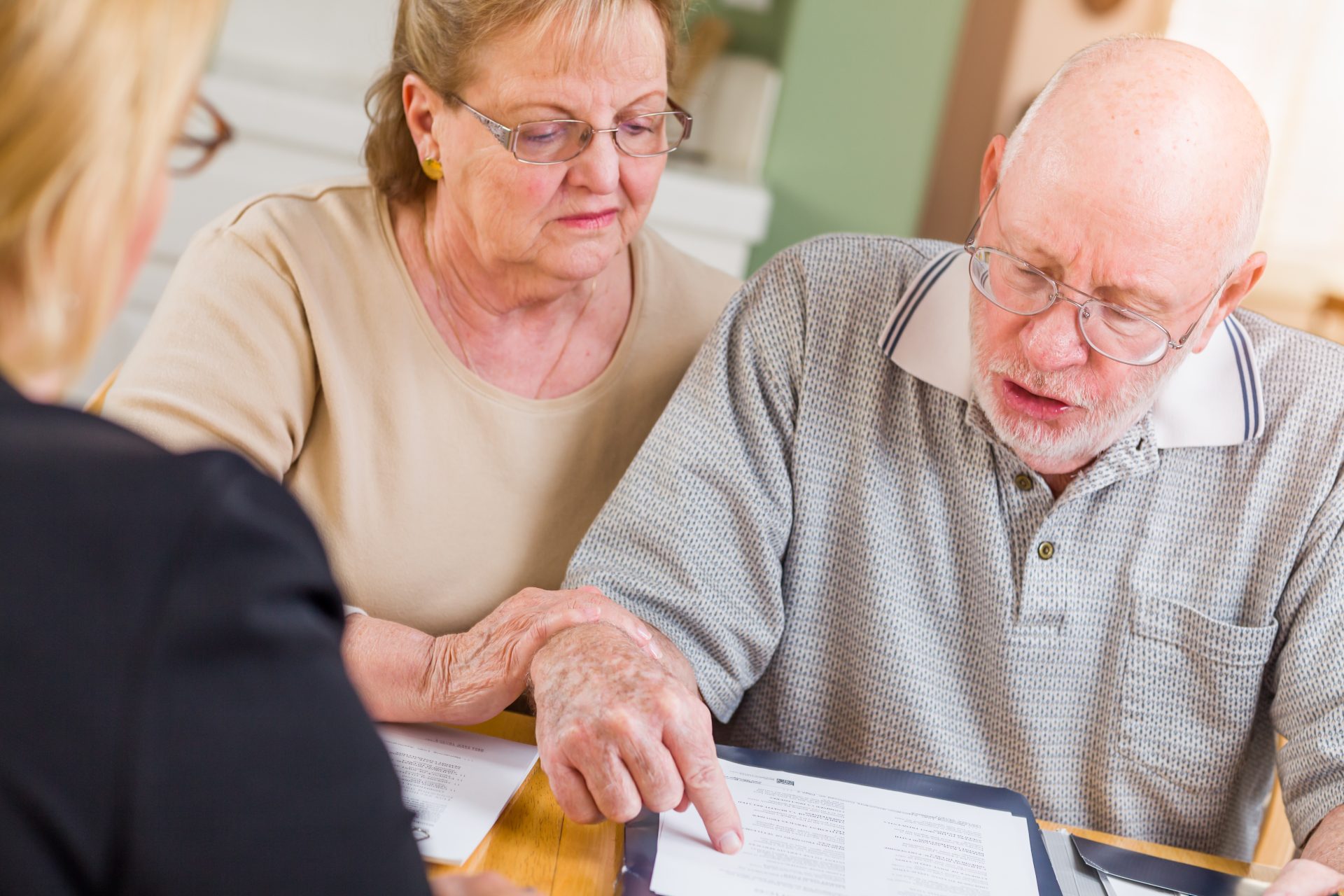 Senior adult couple reviewing estate planning documents with their estate planning lawyer