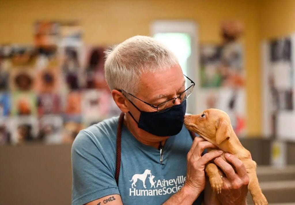 Asheville Humane Society (AHS) staff holding a puppy
